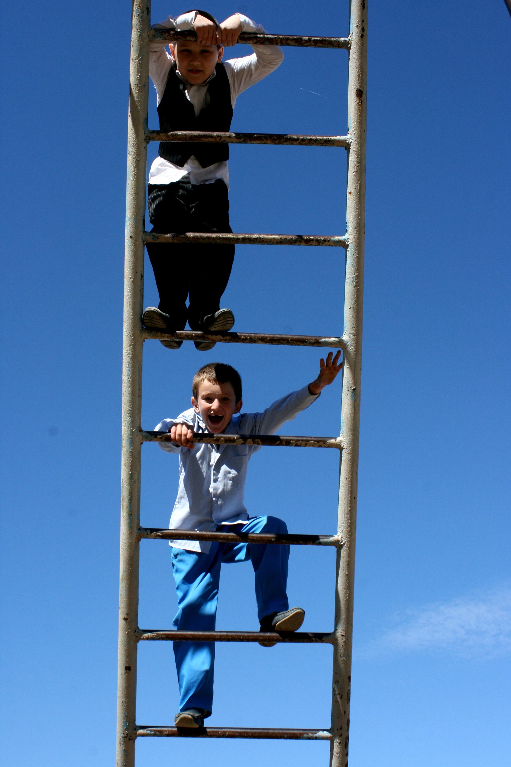 Two schoolboys climbing up the ladder on the school's playground. Astrakhan, 2nd October.